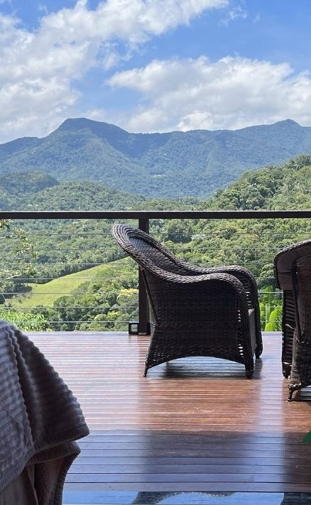 Deck do lodge com poltronas e vista para as montanhas