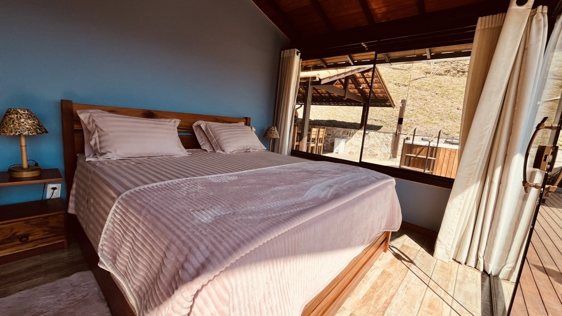Quarto com cama de casal aberto para a varanda