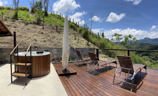 Ofurô e espreguiçadeiras no deck com vista para a serra